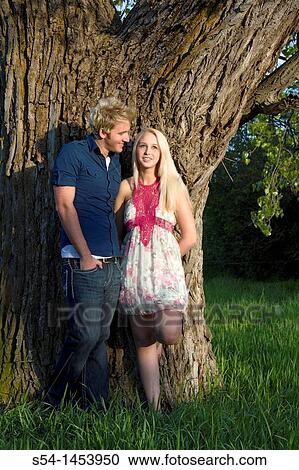 Stock Image - A young couple together in a park. Fotosearch