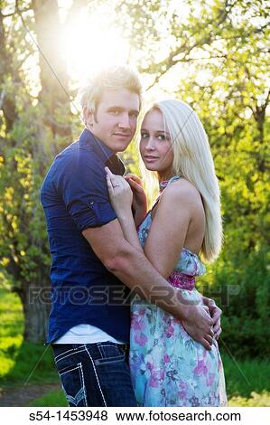Stock Photo - A young couple together in a park. Fotosearch