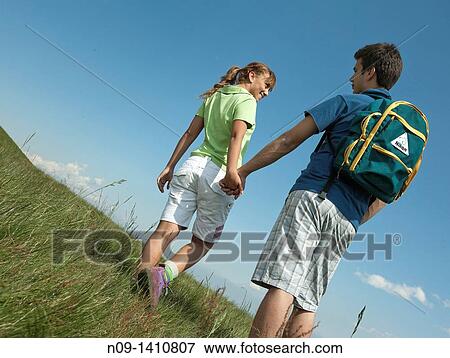 A young couple walking hand in hand View Large Photo Image Stock Photo - A young couple walking hand in hand. Fotosearch