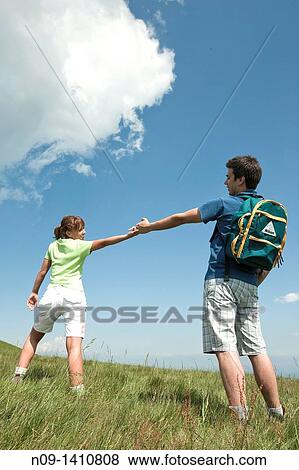 Stock Photo - A young couple walking hand in hand. Fotosearch