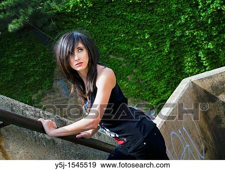 A young dark haired Caucasian female standing outdoors View Large Photo Image Stock Photo - A young dark haired Caucasian female standing outdoors. Fotosearch