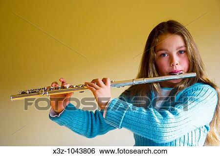 A young female music student playing the flute View Large Photo Image Stock Photograph - A young female music student playing the flute. Fotosearch