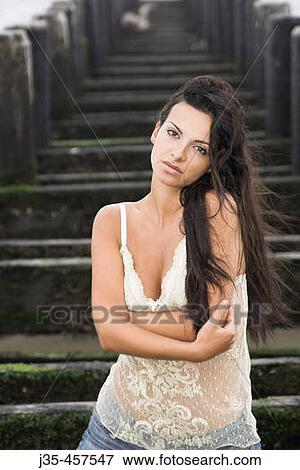 A young girl 20's to 30's with long dark hair, stands in front of pier on a breezy summers day View Large Photo Image Stock Photo - A young girl 20's to 30's with long dark hair, stands in front of pier on a breezy summers day. Fotosearch