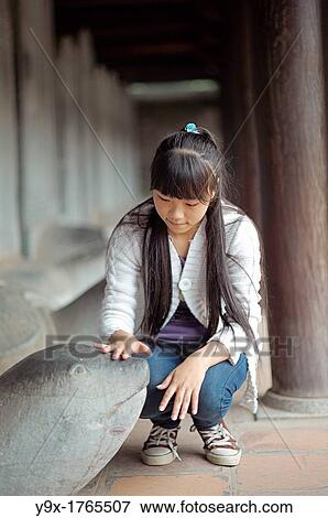 A young girl pats the head of a Turtle Stele statue at The Temple of Literature View Large Photo Image Stock Photo - A young girl pats the head of a Turtle Stele statue at The Temple of Literature. Fotosearch
