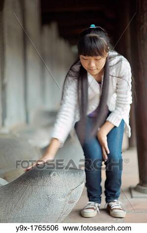 A young girl pats the head of a Turtle Stele statue at The Temple of Literature View Large Photo Image Stock Photograph - A young girl pats the head of a Turtle Stele statue at The Temple of Literature. Fotosearch