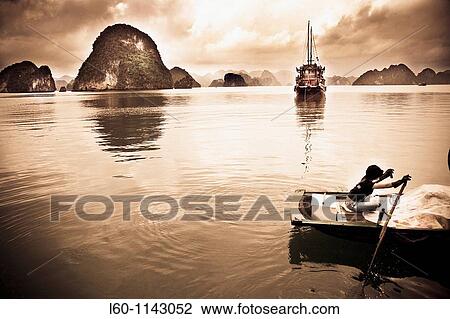 A young girl rows her boat on the waters of HALONG BAY, Vietnam View Large Photo Image Stock Image - A young girl rows her boat on the waters of HALONG BAY, Vietnam. Fotosearch