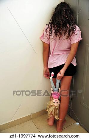 A young girl who is a victim of domestic violence stands in a corner beside the open front house door. View Large Photo Image Picture - A young girl who is a victim of domestic violence stands in a corner beside the open front house door.. Fotosearch