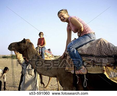 A young girls pets her camel while others look on. View Large Photo Image Stock Image - A young girls pets her camel while others look on.. Fotosearch