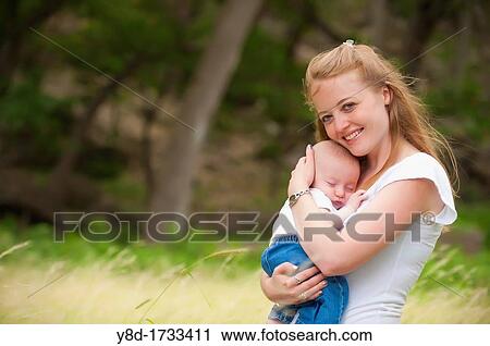 A young happy mother holding her four months old baby boy in a natural environment View Large Photo Image Stock Image - A young happy mother holding her four months old baby boy in a natural environment. Fotosearch