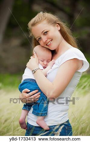A young happy mother holding her four months old baby boy in a natural environment View Large Photo Image Stock Image - A young happy mother holding her four months old baby boy in a natural environment. Fotosearch