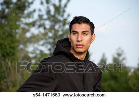 Stock Image - A young hispanic male outdoors.. Fotosearch