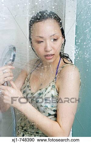 A young Japanese woman stands in a shower while wearing a dress. View Large Photo Image Stock Image - A young Japanese woman stands in a shower while wearing a dress.. Fotosearch