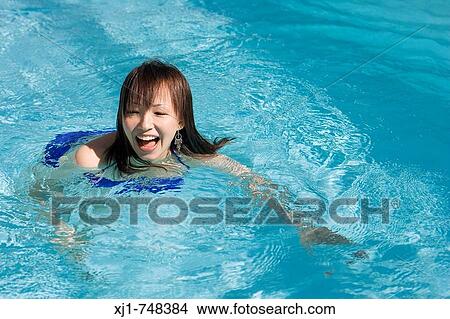 A young Japanese woman swimming in a pool. View Large Photo Image Picture - A young Japanese woman swimming in a pool.. Fotosearch