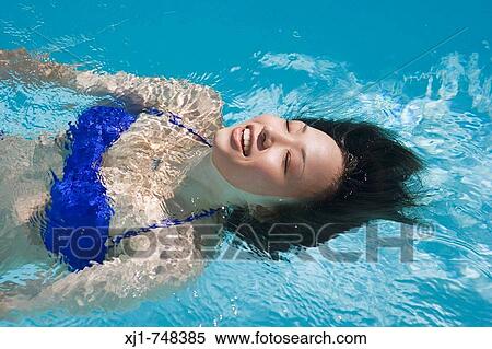 A young Japanese woman swimming in a pool. View Large Photo Image Stock Photography - A young Japanese woman swimming in a pool.. Fotosearch