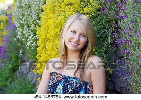 Picture - A young lady outdoors in a flower garden.. Fotosearch