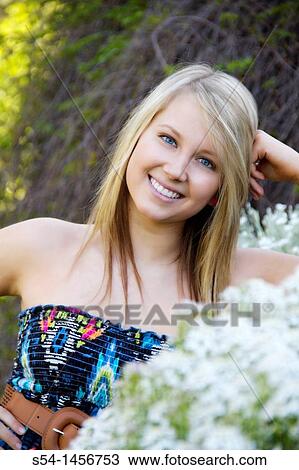 A young lady outdoors in a flower garden. View Large Photo Image Stock Image - A young lady outdoors in a flower garden.. Fotosearch