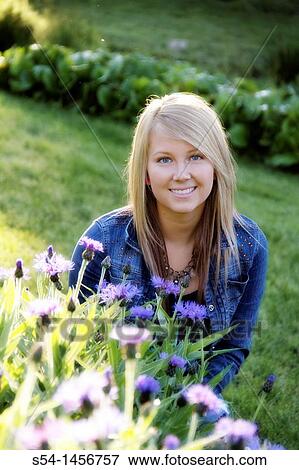 A young lady outdoors in a flower garden. View Large Photo Image Stock Photo - A young lady outdoors in a flower garden.. Fotosearch