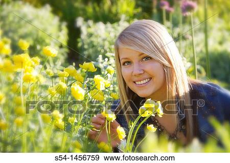 Stock Photo - A young lady outdoors in a flower garden.. Fotosearch