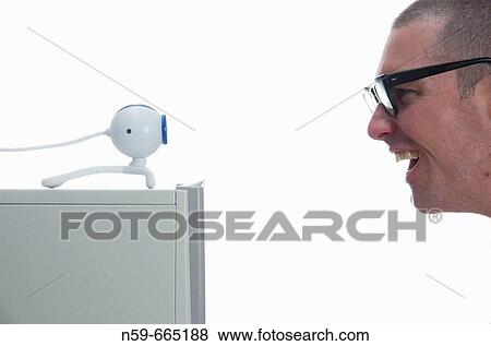 A young male computer user sitting in front of an Internet webcam. View Large Photo Image Stock Photo - A young male computer user sitting in front of an Internet webcam.. Fotosearch