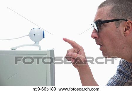 A young male computer user sitting in front of an Internet webcam. View Large Photo Image Stock Photo - A young male computer user sitting in front of an Internet webcam.. Fotosearch