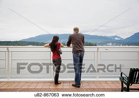 A young man and woman enjoying hte view of Burrard Inlet from Canada Place, Vancouver, British Columbia, Canada View Large Photo Image Stock Image - A young man and woman enjoying hte view of Burrard Inlet from Canada Place, Vancouver, British Columbia, Canada. Fotosearch