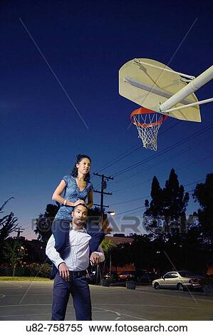 A young man gives a young woman a piggy back ride at a basketball court, Berkeley, California, USA View Large Photo Image Stock Photography - A young man gives a young woman a piggy back ride at a basketball court, Berkeley, California, USA. Fotosearch
