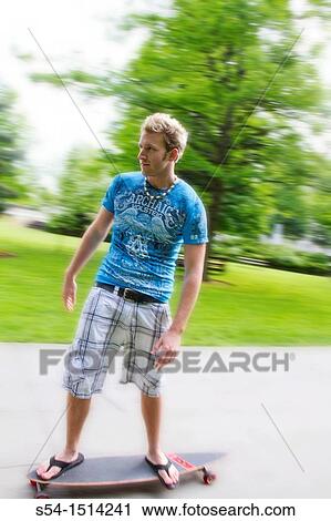 Stock Image - A young man longboarding in Coeur d? Alene, Idaho, USA. Fotosearch
