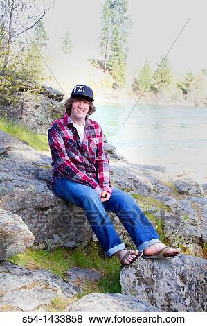 A young man outdoors by the Spokane River, Spokane Valley, Washington, USA. View Large Photo Image Stock Photo - A young man outdoors by the Spokane River, Spokane Valley, Washington, USA.. Fotosearch