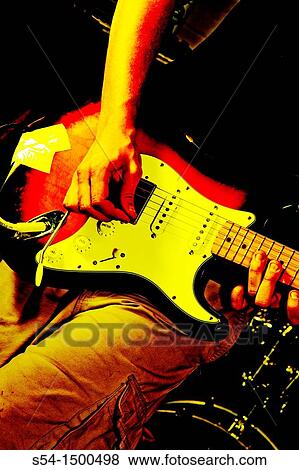 Stock Photo - A young man playing a guitar.. Fotosearch