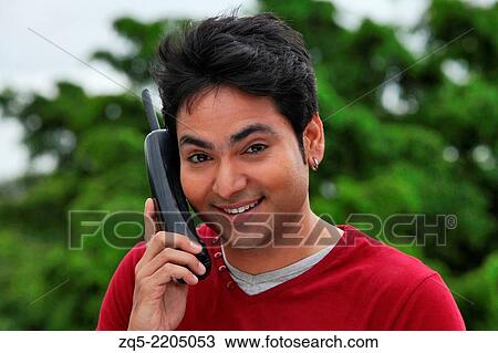 A young man talking over phone, Pune, India. View Large Photo Image Stock Image - A young man talking over phone, Pune, India.. Fotosearch