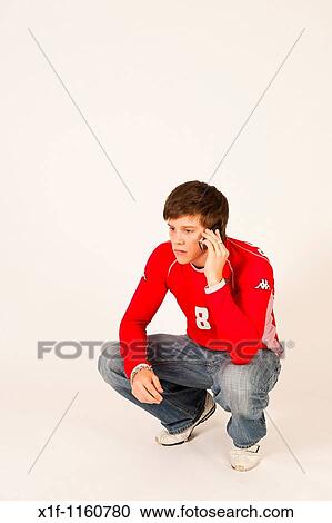 A young man using a mobile telephone View Large Photo Image Stock Image - A young man using a mobile telephone. Fotosearch