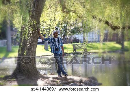 A young man with a camera at a park. View Large Photo Image Stock Photo - A young man with a camera at a park.. Fotosearch
