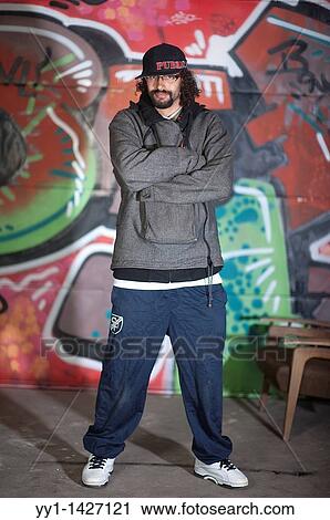 A young man with cap posing in front of a large graffity. View Large Photo Image Stock Image - A young man with cap posing in front of a large graffity.. Fotosearch