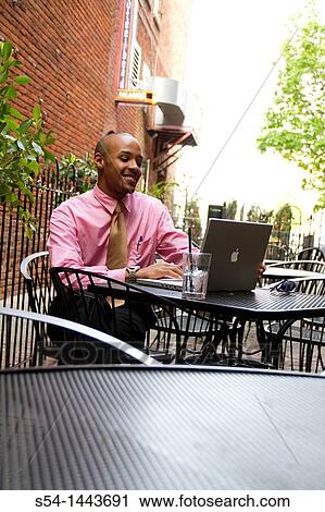 A young man working on a laptop outdoors. View Large Photo Image Stock Image - A young man working on a laptop outdoors.. Fotosearch