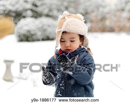 A young mixed ethnicity child playing in the snow View Large Photo Image Stock Photo - A young mixed ethnicity child playing in the snow. Fotosearch