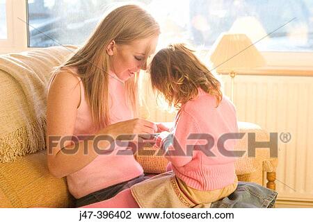 A young mother sitting with 3 year old girl on her knee playing, laughing View Large Photo Image Stock Image - A young mother sitting with 3 year old girl on her knee playing, laughing. Fotosearch