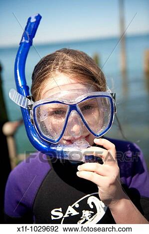 A young pre-teen girl child wearing goggles and snorkel about to go diving into the sea, Aberystwyth Wales UK View Large Photo Image Stock Image - A young pre-teen girl child wearing goggles and snorkel about to go diving into the sea, Aberystwyth Wales UK. Fotosearch