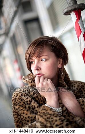 A young slim attractive girl in her late teens or early 20's thinking, looking pensive thoughtful, wearing a fake fur coat, UK View Large Photo Image Stock Photo - A young slim attractive girl in her late teens or early 20's thinking, looking pensive thoughtful, wearing a fake fur coat, UK. Fotosearch