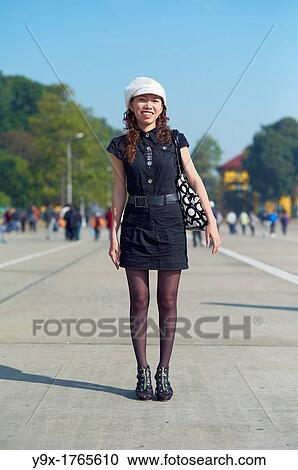 Stock Image - A young stylish woman posing in front of the Ho Chi Minh Mausoleum in Hanoi, Vietnam. Fotosearch