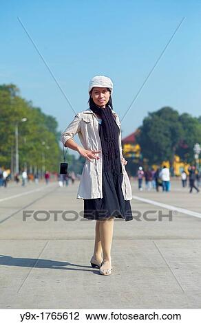 Stock Image - A young stylish woman posing in front of the Ho Chi Minh Mausoleum in Hanoi, Vietnam. Fotosearch
