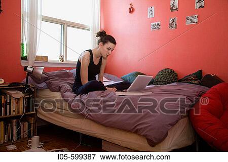 A young woman 20 years old sitting in her room working on university homework View Large Photo Image Stock Photo - A young woman 20 years old sitting in her room working on university homework. Fotosearch