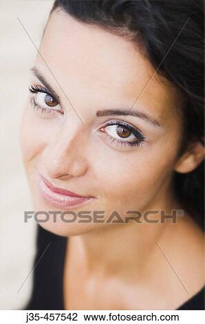 A young woman 20's to 30's with long dark hair a calm expression looks into the camera View Large Photo Image Stock Image - A young woman 20's to 30's with long dark hair a calm expression looks into the camera. Fotosearch