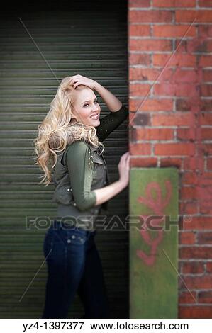 A young woman by a building View Large Photo Image Stock Photo - A young woman by a building. Fotosearch