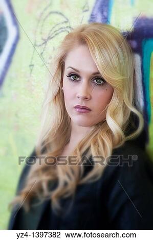 A young woman by a wall covered in graffiti View Large Photo Image Stock Image - A young woman by a wall covered in graffiti. Fotosearch