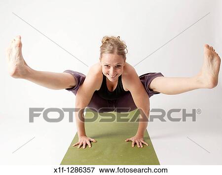 A young woman doing yoga on a green mat View Large Photo Image Stock Photo - A young woman doing yoga on a green mat. Fotosearch