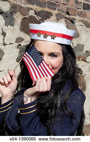 A young woman dressed as a sailor and holding an American flag. View Large Photo Image Stock Photograph - A young woman dressed as a sailor and holding an American flag.. Fotosearch
