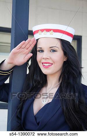 Stock Image - A young woman dressed as a sailor in a pin-up style, saluting. Fotosearch