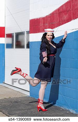 A young woman dressed as a sailor in a pin-up style, holding an American flag View Large Photo Image Stock Photo - A young woman dressed as a sailor in a pin-up style, holding an American flag. Fotosearch
