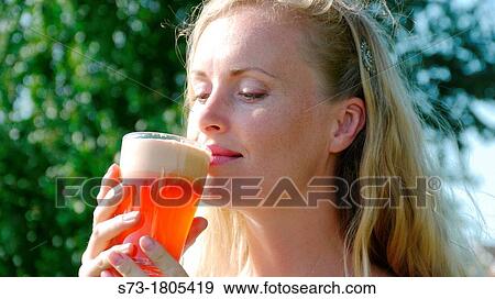 A young woman drinking a glass of apple juice View Large Photo Image Stock Photo - A young woman drinking a glass of apple juice. Fotosearch