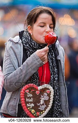 A young woman eating a candy apple at the Annual Fair in Bremen, Germany, Europe View Large Photo Image Stock Photo - A young woman eating a candy apple at the Annual Fair in Bremen, Germany, Europe. Fotosearch